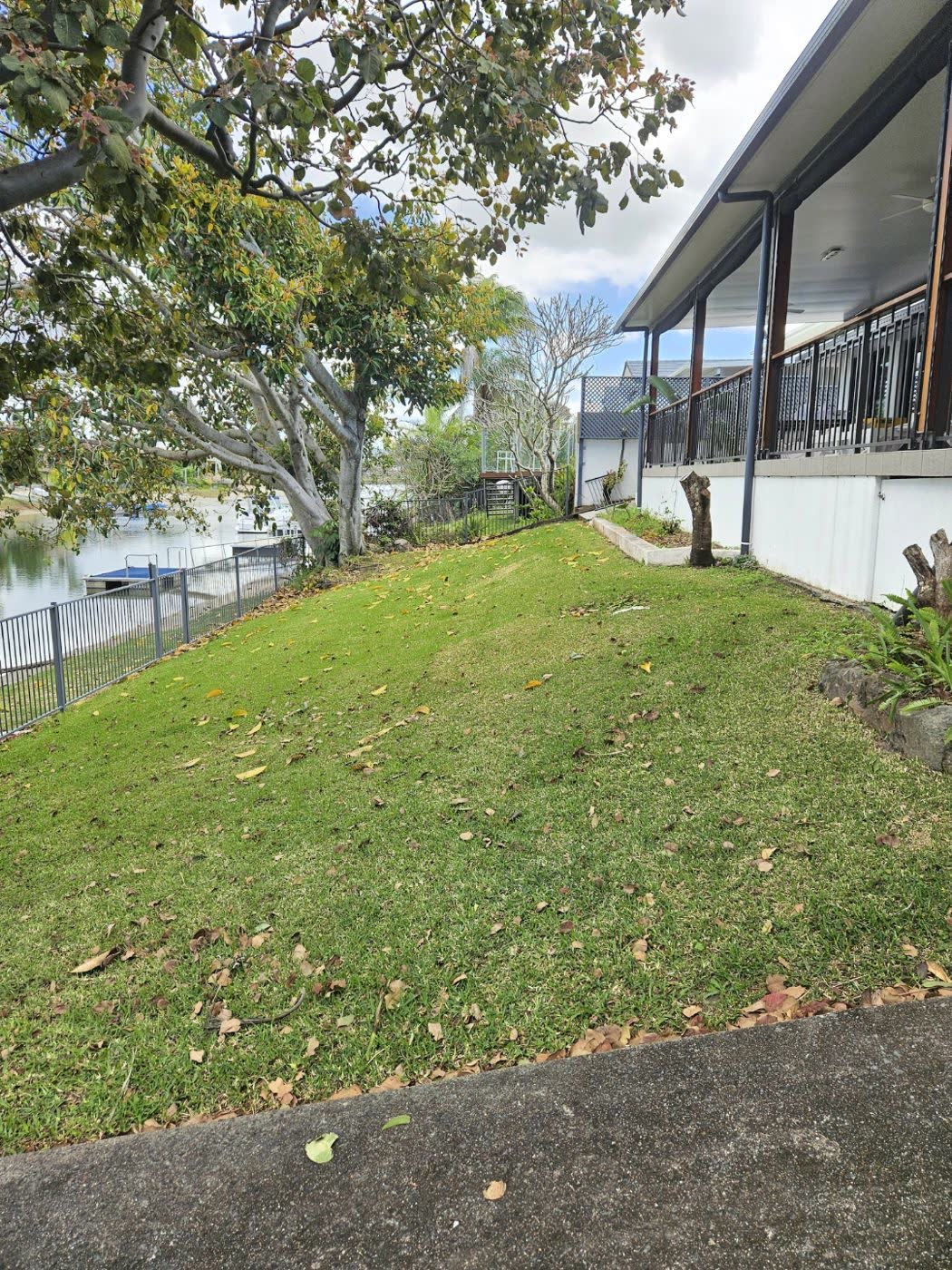 Grassy slope running down to the canal beside the house before the renovation