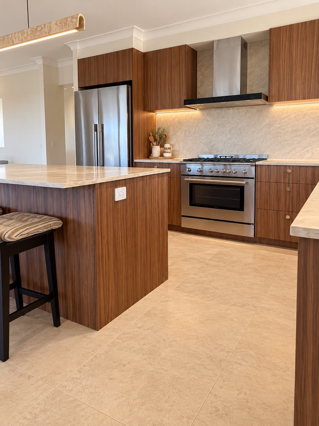 Renovated kitchen with timber cabinetry, stone benchtops, freestanding oven and large-format floor tiles