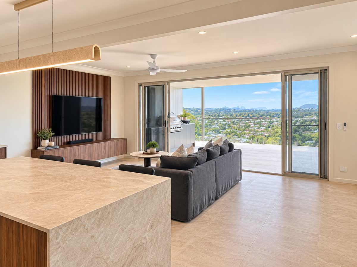 Finished open-plan kitchen and living area with stone island, timber feature wall and views through to the alfresco